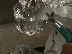 An artist uses a power tool to carve details into an ice sculpture. Stock Footage