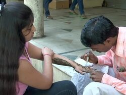 MS Man henna artist painting forearm of teenage girl / Chandigarh, Punjab, India Stock Footage