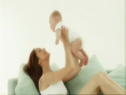Mother and baby playing on cushions Stock Footage
