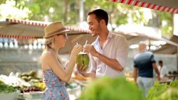 Cute couple share coconut water in sunny Brazilian marketplace Stock Footage