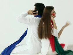 Couple talking on a mobile phone in holi festival  Stock Footage