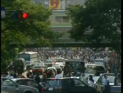 WA Dense, layered cityscape with cars in foreground, train crossing on overpass and crowds moving through middle of frame, Tokyo Stock Footage