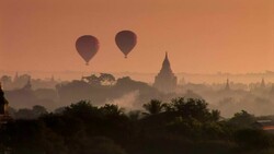 Hot air balloons float above pagodas in Bagan, Myanmar. Stock Footage