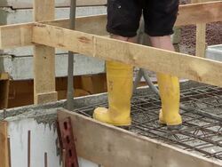 MS Shot of workmen casting concrete at house construction, building site / Hermeskeil, Rhineland Palatinate, Germany Stock Footage