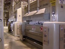 Pan to machines processing cotton on factory floor. Stock Footage