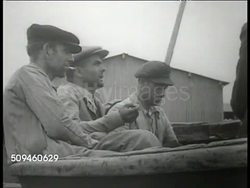 1938: TANGIER (TANGIERS), MOROCCO: Fishing boats docked in harbor. Small group of fishermen sitting in dry docked boat smoking cigarettes. Delegation of fisherman standing in office of Spanish loyalist (Republican, communist) Minister del Rio. Instructional Video