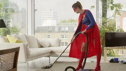Superhero mother vacuuming living room Stock Footage