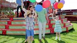 Family celebrating with balloons in amusement park Stock Footage