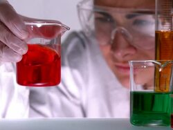 Scientist swirling red liquid in beaker Stock Footage