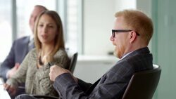 MS Smiling business executive meeting with colleagues in office conference room looking at information on smartphone Stock Footage