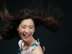 MS SLO MO Asian woman turning toward ,laughing, hair moving in wind / London, Greater London, United Kingdom Stock Footage