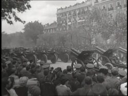 Generalissimo Francisco Franco talks with officers as a parade of military vehicles and soldiers celebrate a victory in the Spanish Civil War. News Clip