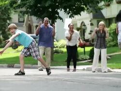 WS TS Kids playing kick ball in street parents watching / Summit, New Jersey, United States Stock Footage