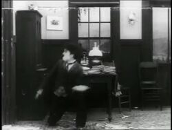 B/W 1916 man (Charlie Chaplin) throwing pie / hits fat man (Eric Campbell) in face (2 shots) / short Stock Footage