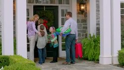Family carrying luggage and Christmas presents follow grandmother into house (dolly-shot) Stock Footage