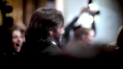 Celebrity couple walk through flashing cameras on awards show red carpet at awards show Stock Footage