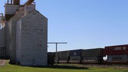 Time-Lapse of train passing a grain barn Stock Footage