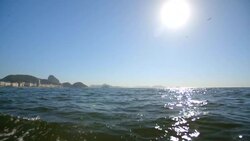 Birds circle the sun over Atlantic Ocean in tracking shot from Copacabana boat Stock Footage