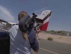 A camera operator films a skydiving plane taking off. Stock Footage