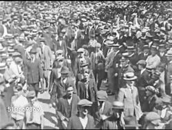 1921: PLIGHT OF UNEMPLOYED IN BOSTON: WS Urban Ledoux ('Mr. Zero) walking w/ men through crowd of people, 'Mr. Zero' 'auctioning' young adult male on stage for human labor, WS Crowd, MS Woman (winning bidder) on stage shaking young man's hand. Instructional Video