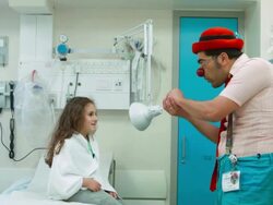 Clown  shows a trick to the girl in hospital Stock Footage