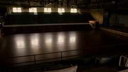 A basketball player dribbles across a darkened court and dunks the ball. Stock Footage