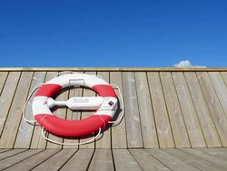 Life belt hanging on wooden pier or boat at midday Stock Footage
