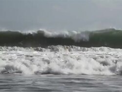 MS Teenage girl walking in front of waves / Seminyak, Bali, Indonesia Stock Footage