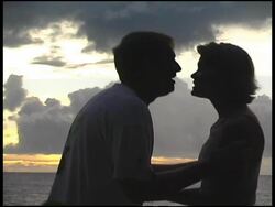 Silhoutted Couple Kiss in front of Sunrise / Sunset Stock Footage