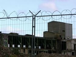 Barbed wire on fence, abandoned factory background, HD Stock Footage