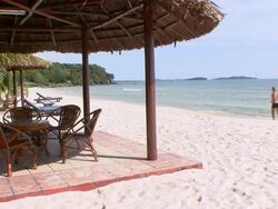 WS Man jogging by quiet beach lounge area / Sihanoukville, Cambodia Stock Footage
