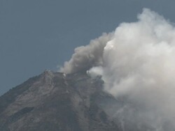 Ash and steam erupt from top of Merapi volcano into clear blue sky; Central Java, Indonesia. 29 October 2010 Stock Footage