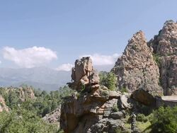 MS Shot of Camper drives on the road through the fantastic rock landscape of the Calanche of Piana, UNESCO World Heritage Site / Gulf of Porto, Corsica, France Stock Footage