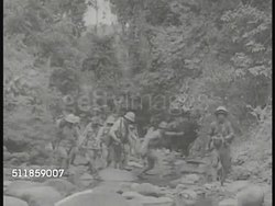 1941: JAPANESE FORCES IN PHILIPPINES: Soldier writing in notebook, group of soldiers walking over jungle stream carrying pieces of artillery gun. LA WS Soldiers firing artillery gun. (poor contrast) WWII, World War II. Instructional Video
