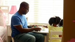 MS Father working on puzzle with young daughter in bedroom Stock Footage