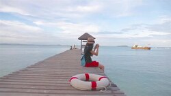 HD Dolly:Woman sitting on wooden bridge and take photo. Stock Footage