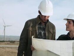 Engineers at wind farm, looking at plans Stock Footage
