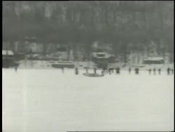A rocket airplane glides across ice and takes off, then crashes in the snow. News Clip