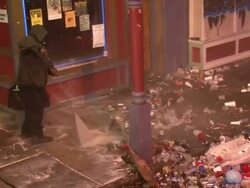 Medium Shot High Angle - Worker spraying trash off sidewalk at night / New Orleans Louisiana Stock Footage