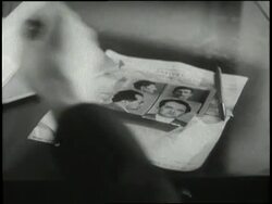 An Interpol agent looks through photographs of criminals. News Clip