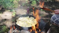 Man prepares fried potatoes on the campfire. Stock Footage