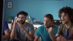 Guys sitting on couch watching tv and cheering Stock Footage