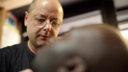 New York City barber combs and trims customer's beard with precision Stock Footage