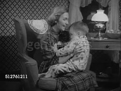 1953: TWO YEAR OLD: Parents sitting in living room reading, young boy running to mother, hitting dad's paper, sitting in father's lap, kissing cheek, father getting up w/ boy. Instructional Video