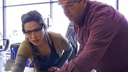 Mature Caucasian male and young Hispanic woman measure plywood in community woodworking shop Stock Footage