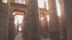 The sun shines between pillars in an ancient temple in Karnak, Egypt. Stock Footage