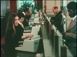 A hand slides a credit card through a magnetic card reader. News Clip