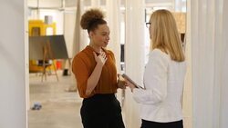 Businesswoman gesturing while communicating with colleague Stock Footage