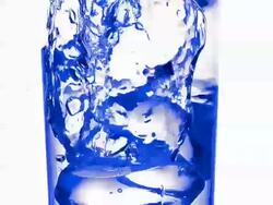 CU SLO MO Ice cubes falling into glass of water against Blank Backdrop / Vieux Pont en Auge, Normandy, France Stock Footage