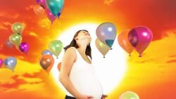 A pregnant woman dances in front of a sunset with balloons floating by. Stock Footage